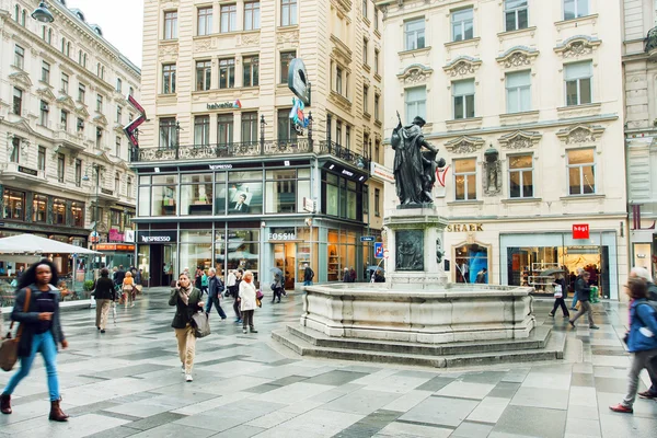 Muitas pessoas caminhando na parte central da capital austríaca com edifícios antigos e modernos — Fotografia de Stock