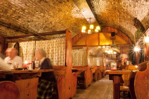 Historisches Restaurant unter der Erde eines Gebäudes aus dem 17. Jahrhundert mit Menschen beim Abendessen — Stockfoto