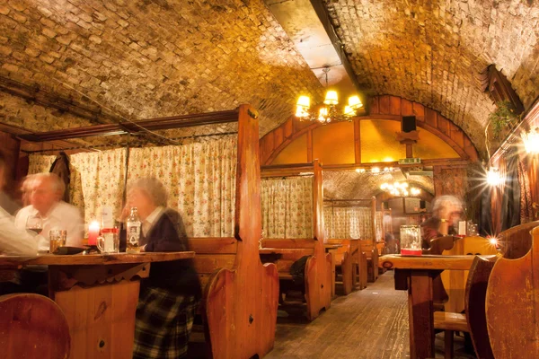 Restaurante histórico subterráneo del edificio del siglo XVII con gente cenando Imagen De Stock