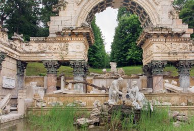 Antik taş kemer altında heykel. Schonbrunn Sarayı yakınlarındaki Kraliyet parkı, Viyana.