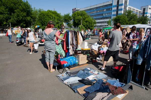 Looking for second hand jeans and used items on the open air flea market — Stock Photo, Image