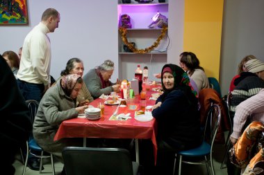 Poor men and women have a food at charity dinner