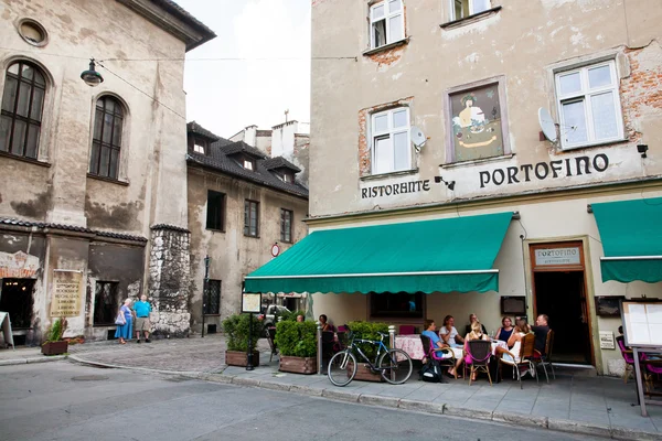 Ihmiset syövät illallista italialaisen ravintolan ulkoterassilla — kuvapankkivalokuva