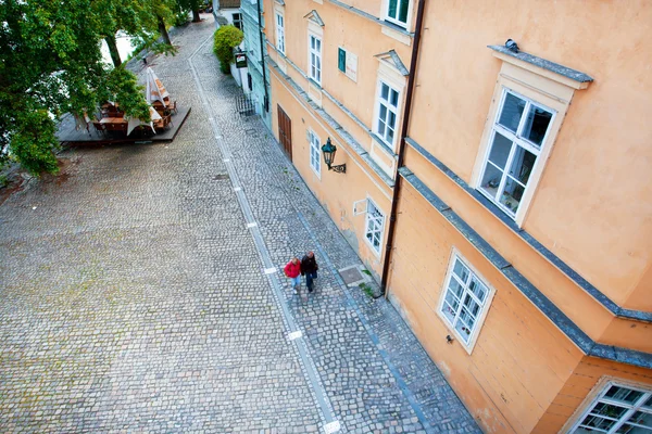 Två turister promenad förbi gamla huset genom kullerstensbelagda gatan — Stockfoto