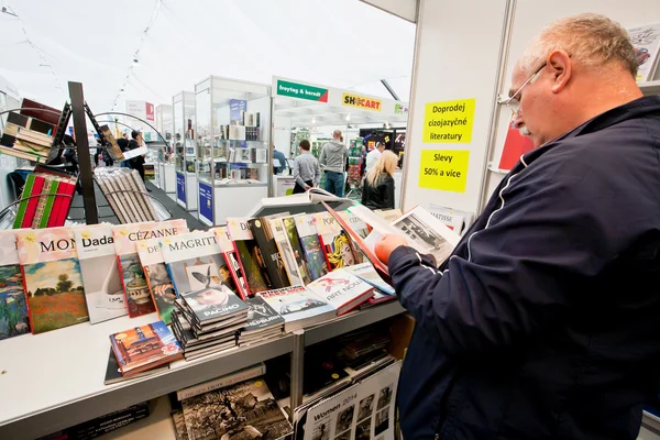 Many people choose art and photo books at the indoor book market — Stock Photo, Image