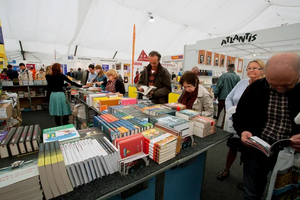 Muchos hombres y mujeres eligen libros en el mercado de libros de interior — Foto de Stock