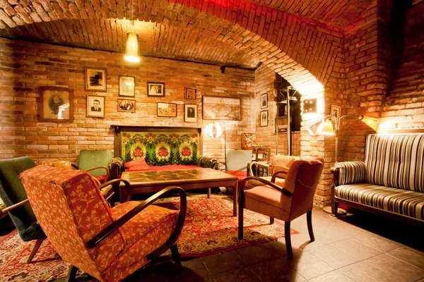 Interior of cozy cafe with armchairs and sofas in the style of an old apartment in a historical house — Stock Photo, Image