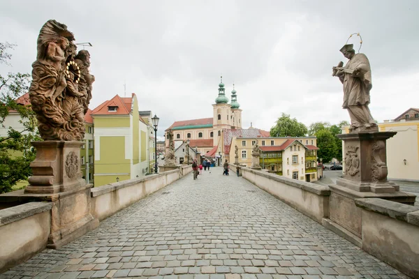 Oude brug met kinderkopjes en beelden van heiligen in de stad — Stockfoto