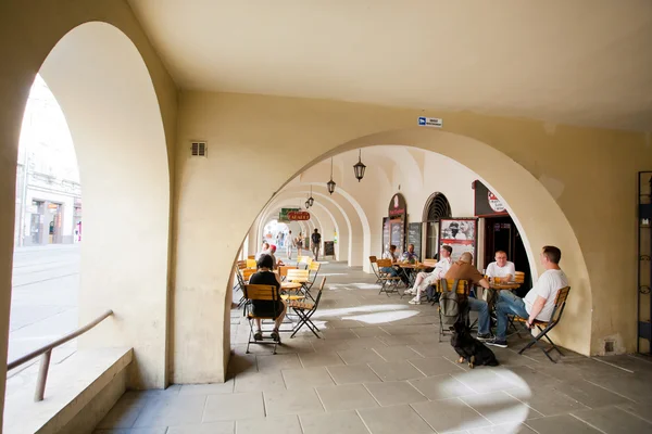 People sitting at old city cafe — Stock Photo, Image