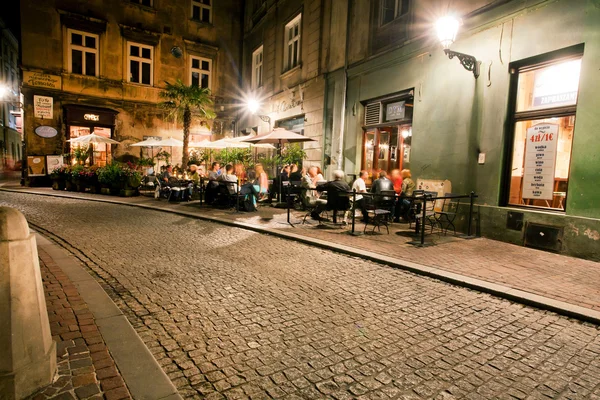 People drink outside the cafe in historical building of old polish city — Stock Photo, Image