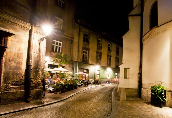 Mörk gata i gamla staden med cobble sten road och barer och kaféer runt — Stockfoto