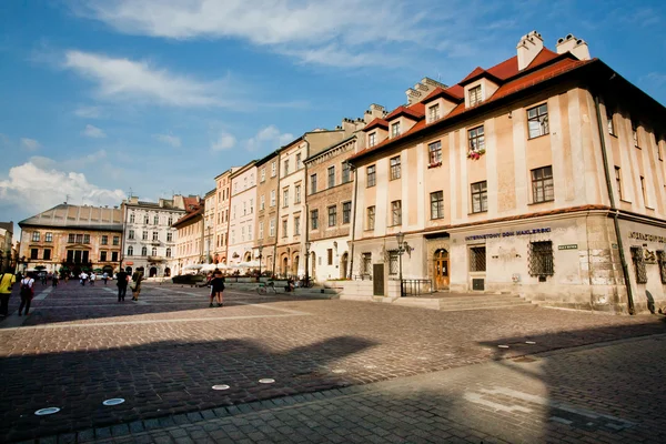 Люди, що йдуть в довгі тіні сонячний день в центр міста, польська — стокове фото