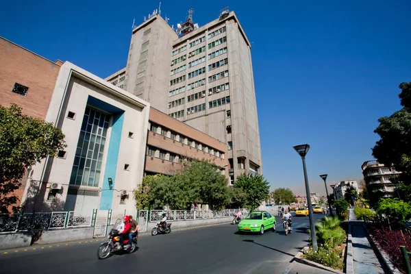 Coches y bicicletas en carretera soleada con edificios de la calle . —  Fotos de Stock