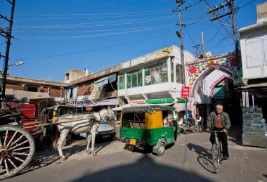 Man driving cycle past retro transport on the indian street