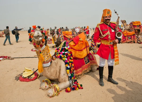 Musician in vivid form with saxophone in desert — Stockfoto