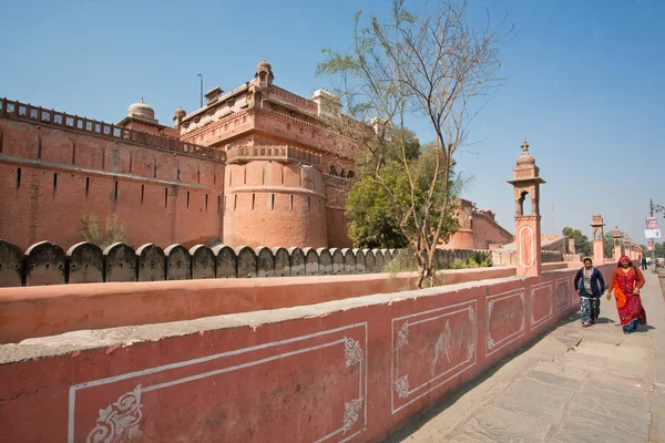 Women walk past the monumental wall in India — Stockfoto