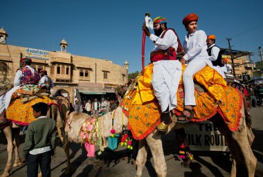 Brave camel riders with swords going with caravan