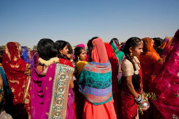 Красивые женщины в красных платьях сари идут на фестиваль пустынь — стоковое фото