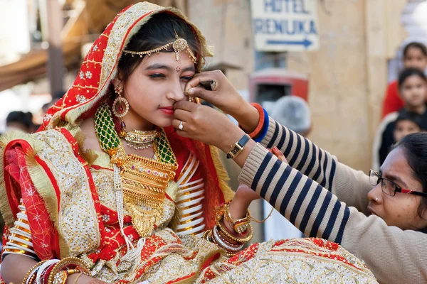 Мама помогает молодой красоте носить традиционные украшения — стоковое фото