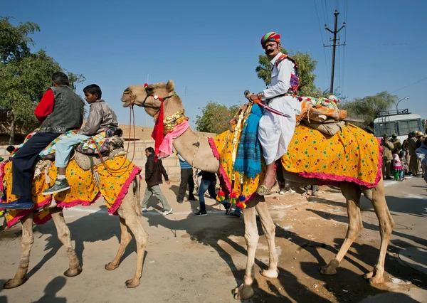 Colorful caravan of camels and safari riders — Stock Photo, Image
