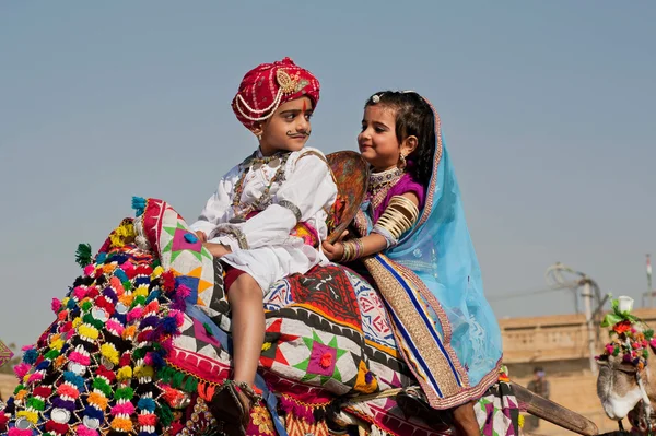 Boy and girl driving the camel on the traditional Desert Festival — Stock Photo, Image