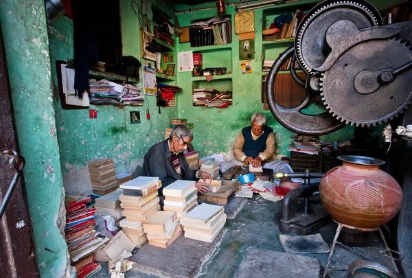 Lieu de travail de deux personnes âgées réparant des livres anciens — Photo