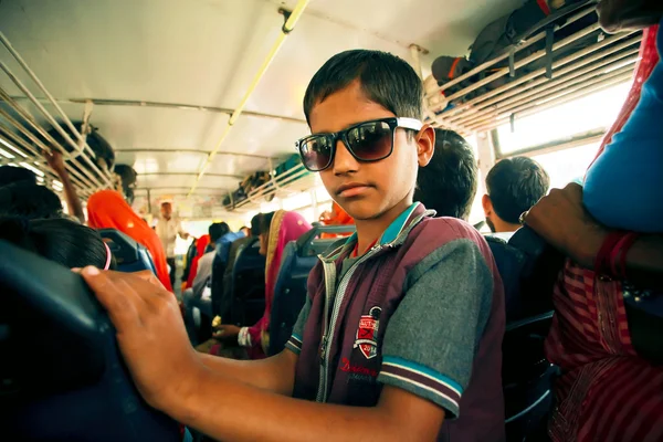 Kid in sunglasses driving inside a city bus — Stock Photo, Image