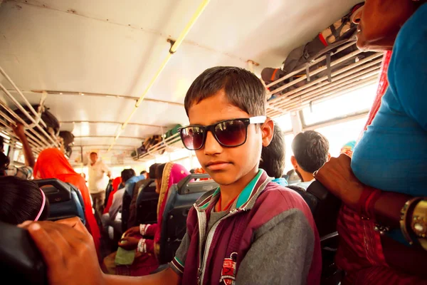 Junge mit Sonnenbrille steht im voll besetzten indischen Bus — Stockfoto