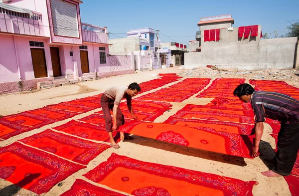 Workers of a textile factory turn painted scarf, dried in the sun — Stock Photo, Image