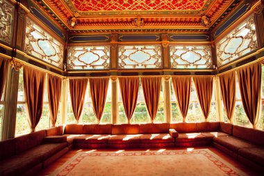 Turkish sofas and colorful ceiling in traditional Ottoman room