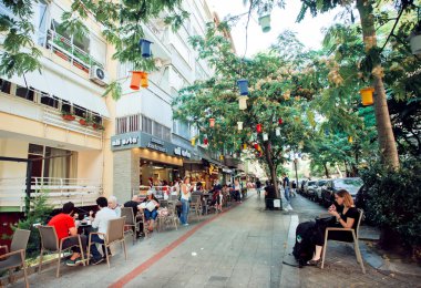 People relaxing in the shade near outdoor cafe