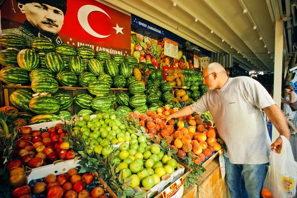 Mann wählt Pfirsiche an einem Marktstand in Istanbul — Stockfoto