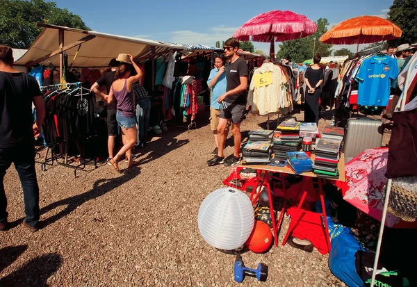 Mujeres y hombres mirando mercancías en los montones de segunda mano —  Fotos de Stock