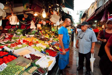 Serious customer and trader of food market talking on the busy street