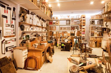 Art space of painters with shelves full of books, brushes and paints