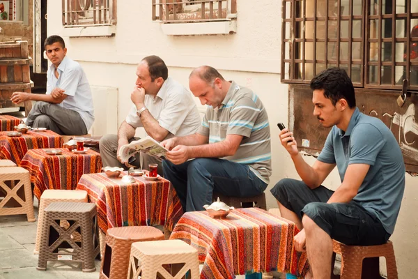 Männer lesen Nachrichten und trinken Tee im traditionellen Outdoor-Café der türkischen Hauptstadt — Stockfoto