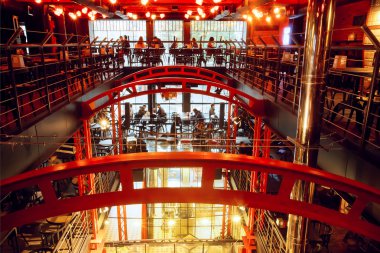 Üç düzeyde büyük bir modern restoran içinde gevşeme insanlar var