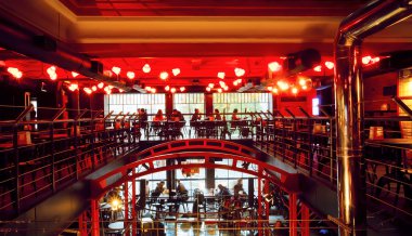 Modern şehir bar kırmızı ışık alan içinde oturan akşam ziyaretçi