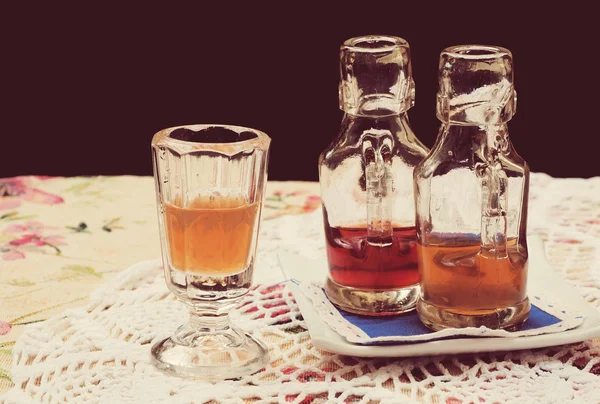 レトロなテーブル クロスの上のクリスタル ガラスでオレンジの食前酒 — ストック写真