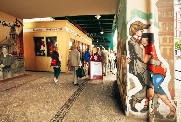 Berliners andando pela loja de fast food com graffiti de pessoas dançando — Fotografia de Stock