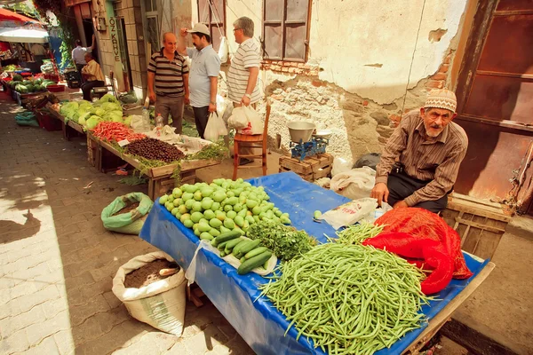 Starý muž prodává bylinky, fazole a hrušky na rustikální pouliční trh v Turecku — Stock fotografie