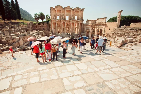 Turisták napernyők közelében Ephesus város történelmi Celsus könyvtára — Stock Fotó