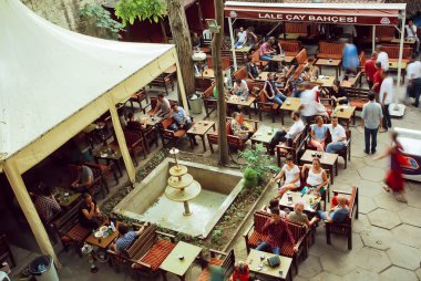 Crowd of people drinking coffee in outdoor cafe in popular touristic area of turkish capital  