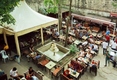 Cafe in historical courtyard with local people and tourists relaxing outdoor 