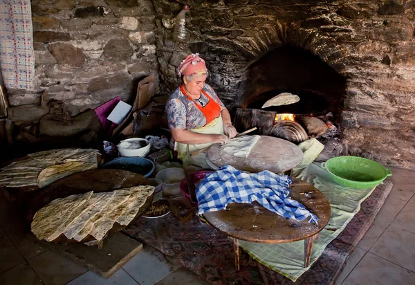 Senior woman making pastry for traditional food Gozleme inside rustic kitchen of old turkish village — Stock Photo, Image