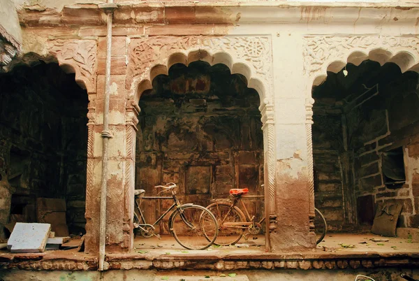 Columnas y arcos de una antigua casa con dos bicicletas retro abandonadas, India — Foto de Stock