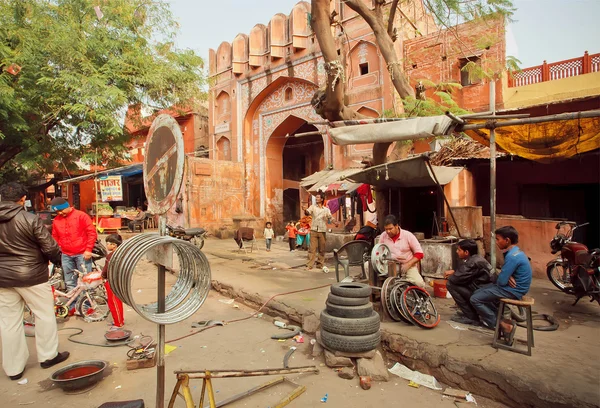 Technicien travailleurs de réparation de roues pour voitures et vélos dans un magasin de rue de la ville indienne — Photo