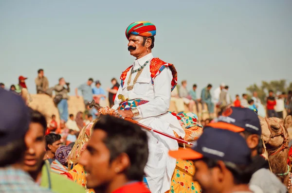 Wielbłąd kierowcy w retro indyjskiego stroju jazdy przez tłum popularny festiwal pustyni — Zdjęcie stockowe