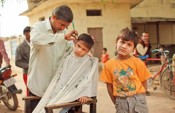 Oidentifierade barn i utomhus frisören gör frisyr av byn frisör — Stockfoto