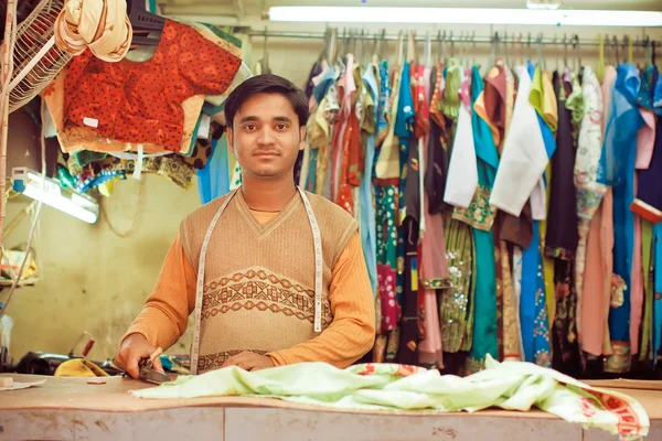 Young tailor sews clothes in a workshop for making dresses — Stock Photo, Image